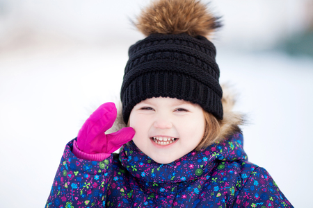 Cute toddler girl outdoors on a sunny winter day, walking, snowy day.の写真素材