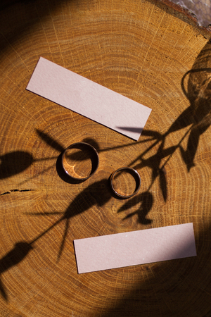 Wedding rings on a wooden texture surface, rustic stule, minimalism. Flat lay, top view, copy spaceの写真素材