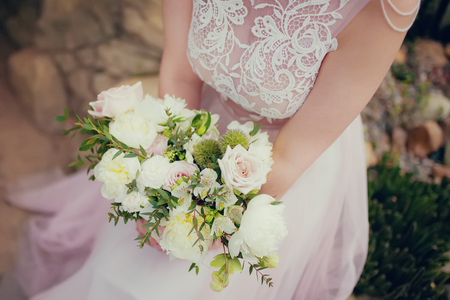 Bride wearing beautiful vintage dress, holding wedding bouquet. close up, copy space, toningの写真素材
