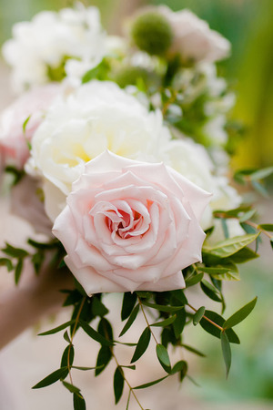 Horizontal wedding bouquet of white peony and coffee roses. Lots of greenery.の写真素材