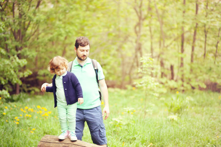 father and daughter walking in the forest together, family leisure, lifestyle, active life. Toned photo with copy spaceの写真素材