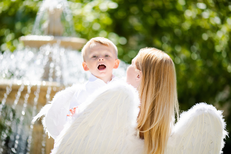 Beautiful mother and her toddler son wearing angel costumes. Cheerful moment, loving family. Mom is the Guardian angel for her child concept.の写真素材