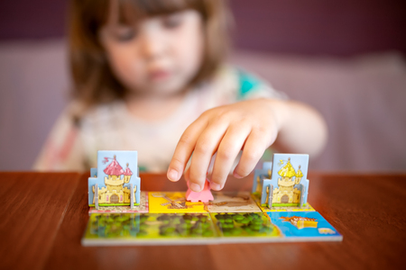 Adorable toddler girl playing board game indoors. Games for little kids.の写真素材