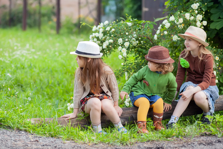 Three little adorable sisters girls having rest at the ranch together. Wearing straw hats. Kids fashionの写真素材