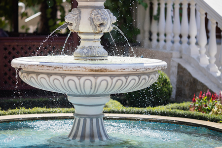 Large round cascading concrete fountain in the park, sunny day.の写真素材