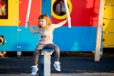 Little girl is engaged in the simulator at the sport ground outdoors