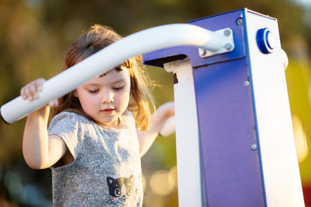 Little girl is engaged in the simulator at the sport ground outdoors