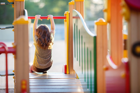 Cute happy little girl playing on outdoors playground