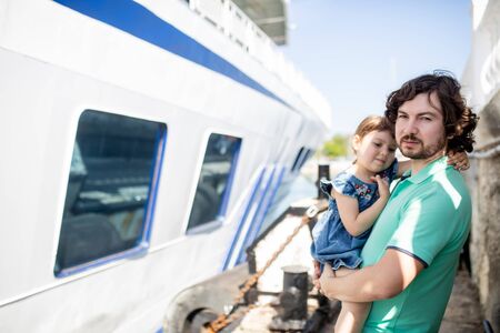 Dad and daughter are sailing on a boat on the river at summer. Family of tourists on excursions.の写真素材