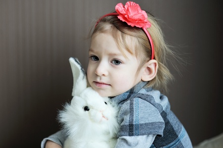 Portrait of adorable baby girl with flower headband and toy rabbitの写真素材