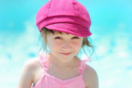 Cute little girl sitting by a swimming poolの写真素材
