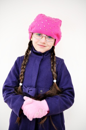 Portrait of toddler girl with pigtail in pink barret and purple coat, isolated on white backgroundの写真素材