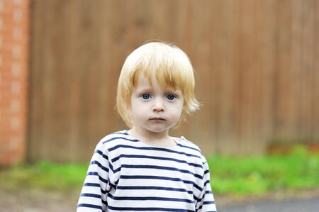 Close-up portrait of cute baby boy posing outdoorの写真素材