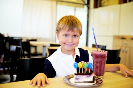 Portrait of toddler boy celebrating his birthday in a restaurantの写真素材