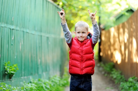 Portrait of cute little boy giving the devil horns gestureの写真素材