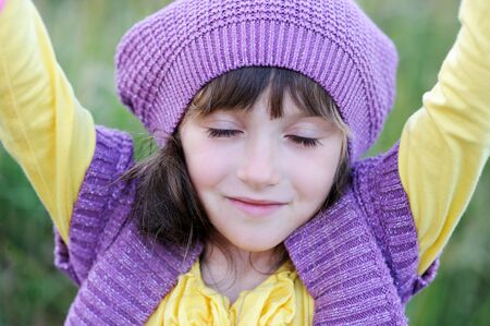 Close-up portrait of little girl in violet hat with closed eyesの写真素材