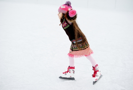 Little girl having fun on ice skating rink outdoorsの写真素材