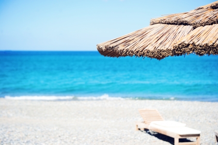 Straw umbrella on tranquil beach on Creteの写真素材