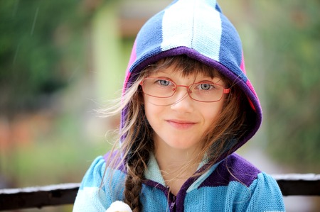 Close-up portrait of little girl wearing glasses and hoodyの写真素材