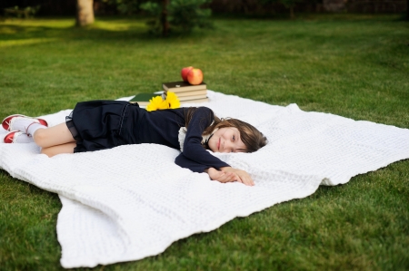 Young girl in navy school uniform relaxing in backyardの写真素材
