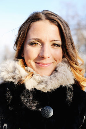 Outdoor portrait of beautiful young bride wearing fur mantle