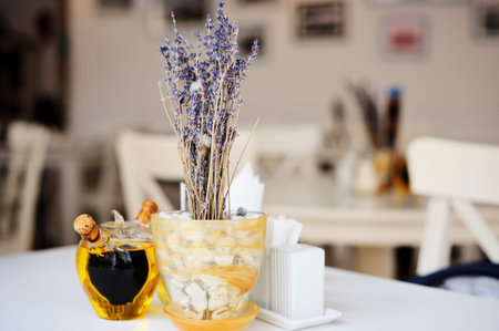 White table in the restaurant with lavender in pot and olive oil