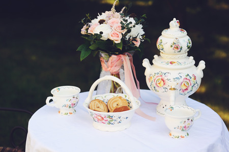 Tea table for two outdoor in the garden with elegant country style tablewareの写真素材