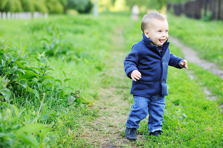 Portrait of adorable blond baby boy walking in parkの写真素材