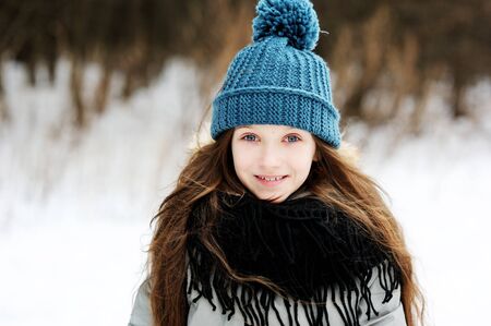 Funny little girl having fun in beautiful winter park with snowballsの写真素材