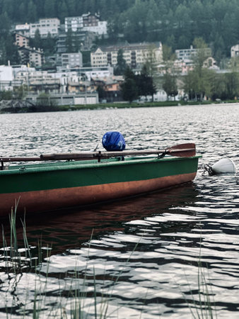 Boat on the shore of a lake, in the background the city.