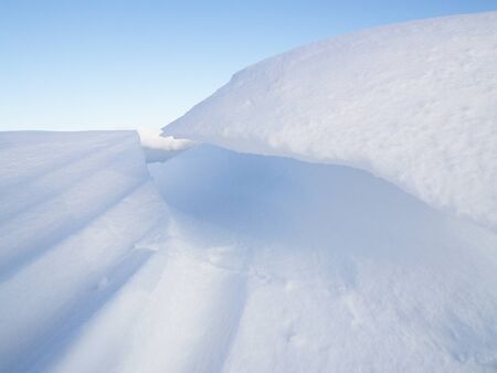 Snowdrift against a lightblue skyの写真素材