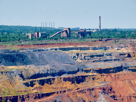 Upper levels of the iron ore open cast mine with crushing plant and pipes one the background