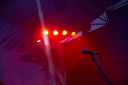 Microphone on stage with red lights and fogの写真素材