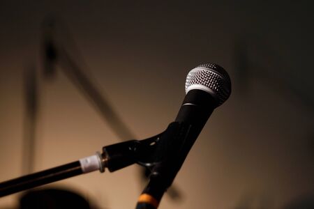 Vocal microphone with stand on the stage with shadows on highlighted backgroundの写真素材