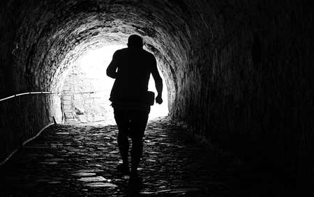 Man coming out of a dark tunnel. black and white.の写真素材