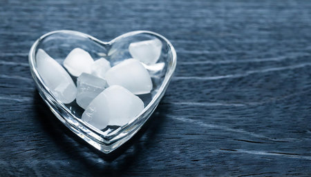 Heart shaped ice cubes on black wooden background. Shallow dofの素材