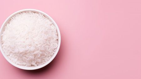 Bowl with boiled rice on pink background, top view. Space for textの素材