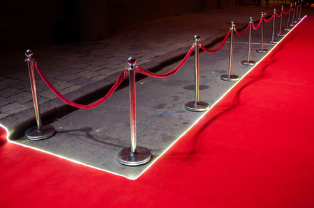 Long red carpet between rope barriers on entrance.の写真素材