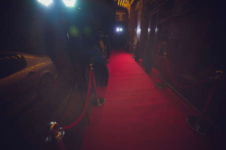 Long red carpet between rope barriers on entrance.の写真素材