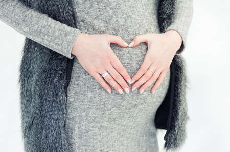Portrait of red headed pregnant woman in snowy forestの写真素材