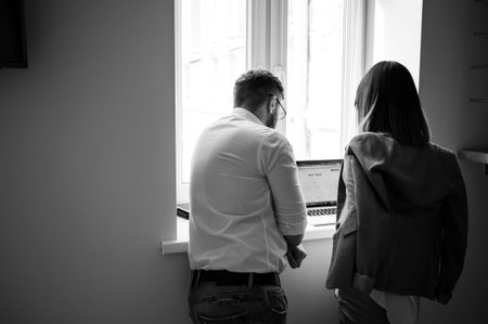 Young coworkers using laptop in office