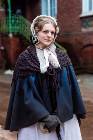 Outdoors portrait of a young victorian woman walking old cityの写真素材