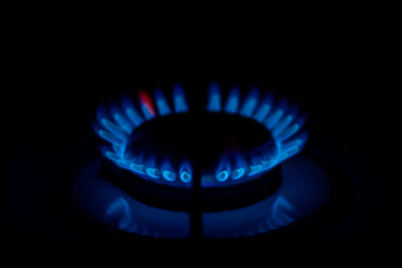 Blue flames of a gas burner on a black background close-up