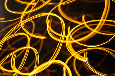 abstract light lines on a dark background, yellow and orange colorの写真素材