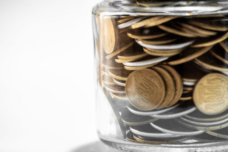 Coins in a glass jar with filter effect retro vintage style.