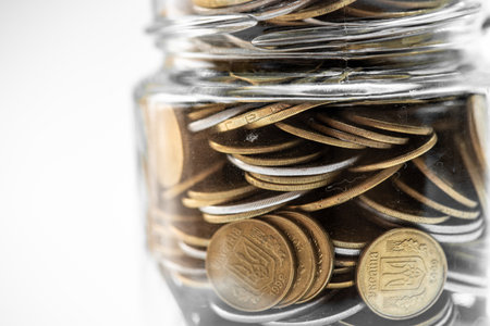 Coins in a glass jar with filter effect retro vintage style.の写真素材