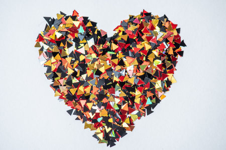 Heart made of multicolored confetti on a white background.の写真素材