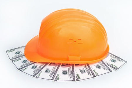 Construction hard hat on a background of dollarsの写真素材