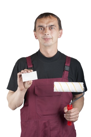 Painting contractor in overalls with paint roller and business card in handの写真素材