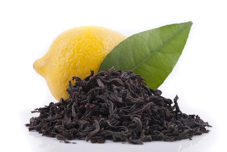 Black tea, lemon and green leaf on a white background の写真素材